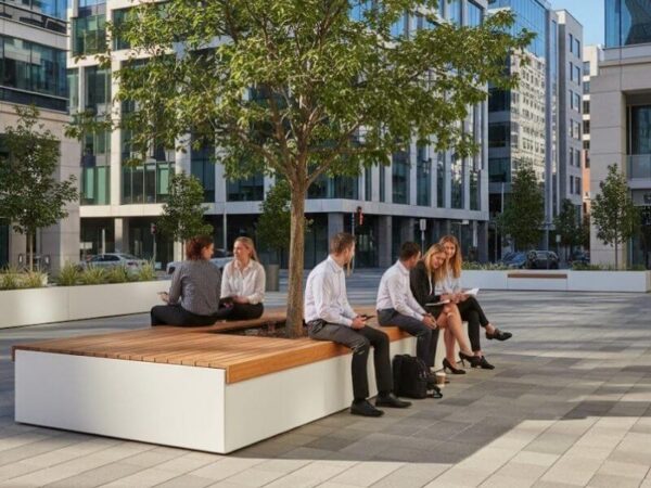Modern urban plaza with white architectural planter benches and shade trees.
