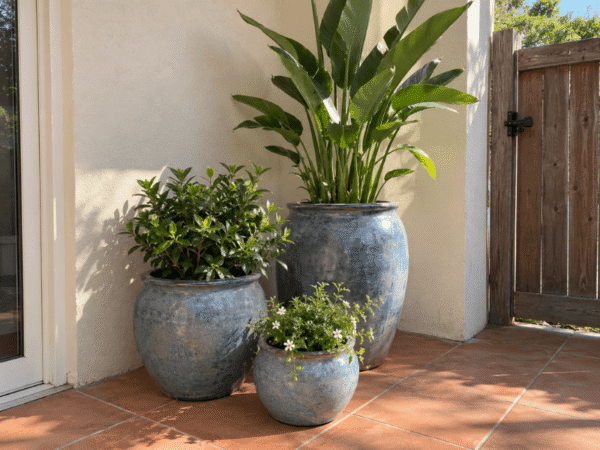 Group of three decorative ceramic garden pots in different sizes arranged on a residential patio