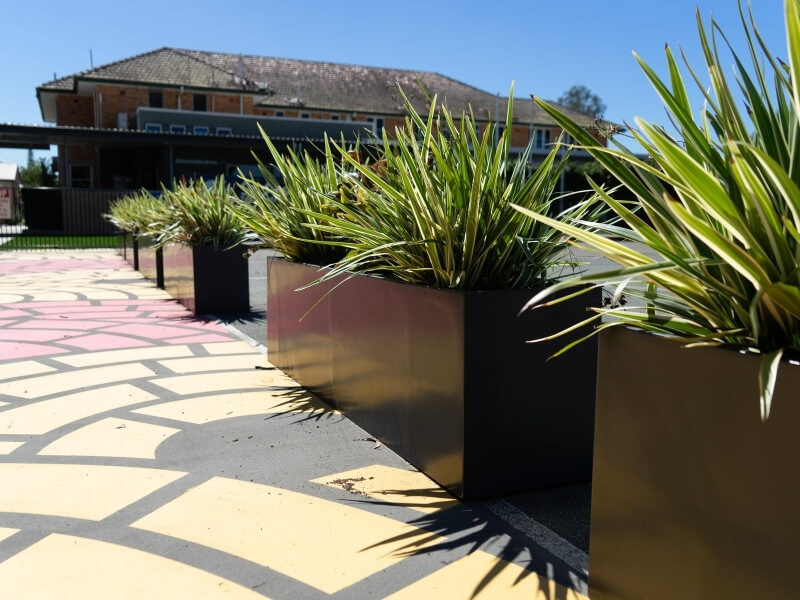 Modern fibreglass planters with trees in a premium outdoor setting.