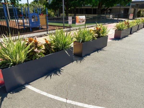 Linear rectangular planter boxes guiding pedestrian movement through a public outdoor space
