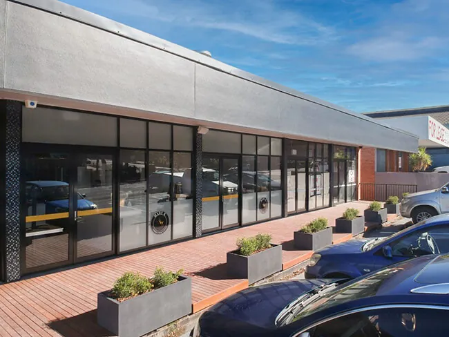 rectangular concrete planters in front of parking area