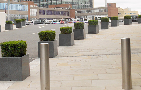 View of paddington central parking lot through granite planters